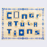 Wooden sheet with pop out puzzle piece elements. The elements spell out "Congratulations"