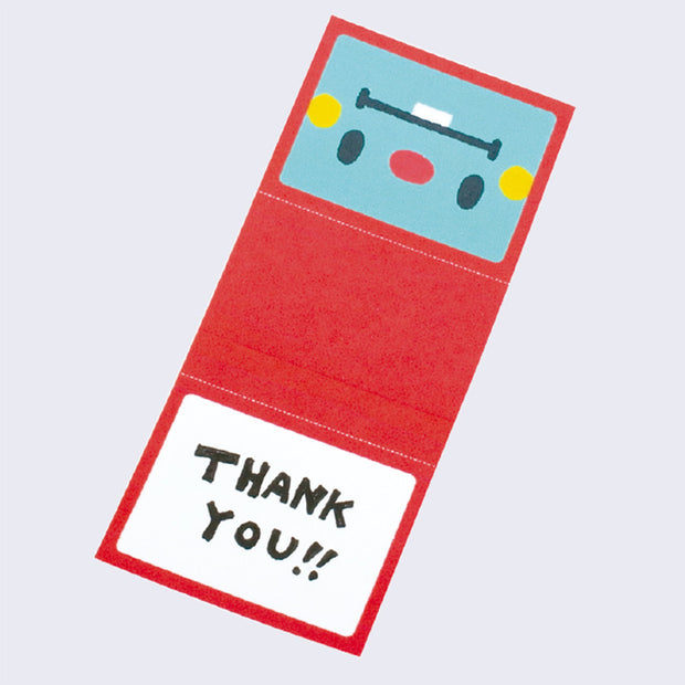 A tiny foldable paper card with a red robot face laid flat. One side is left blank. Example message on card says thank you.