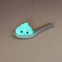 Enamel pin of an illustrated soup dumpling in a large ramen spoon. Dumpling has a smiling face. Pin is glowing in the dark.