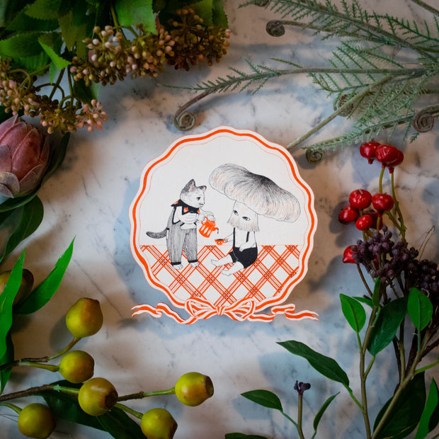 Illustration of a kind looking cat wearing pinstriped overalls, pouring coffee into a mug being held by a sitting figure with a large mushroom head. They are positioned on a plaid orange and white flooring. A circular orange striped bow surrounds the piece.