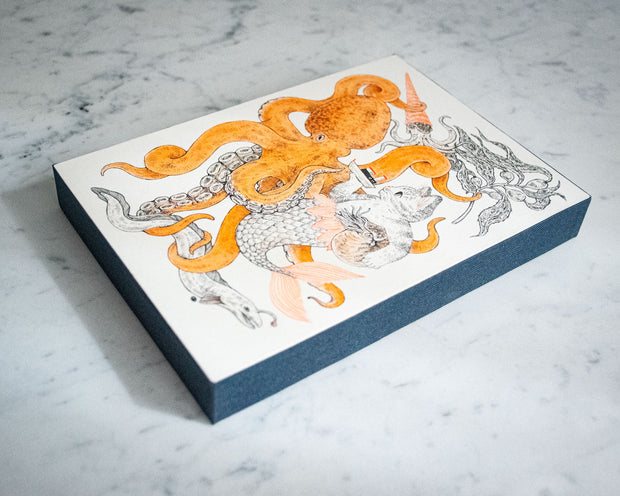 Ink drawing on white panel with orange accent coloring of a large octopus intertwined with a cat mermaid. The cat holds a small ship in one hand and a Nautilus under the other arm. A squid and an eel swim nearby with kelp. Side of panel is wrapped in navy blue fabric.