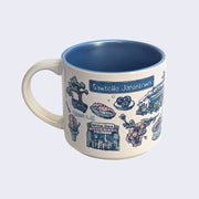 White ceramic mug with a metallic blue interior and various illustrations on it, all within a color scheme of blue, pink, white and green. Illustrations include a bonsai tree, sashimi, sushi rolls, cherry blossoms, a food stall that says "Ketchie's Stand," a street sign that says "Sawtelle Japantown" and a shaved ice cone.