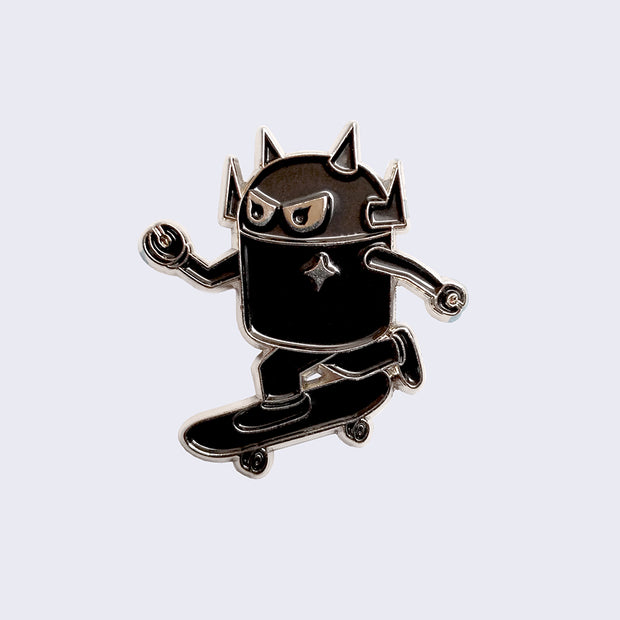 Enamel pin of a black robot with a silver outline, riding a skateboard mid push.
