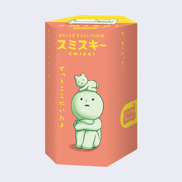 Peach colored cylindrical display box with an illustration of a small simplified figure sitting and hugging its knees, with a small cat on its head.