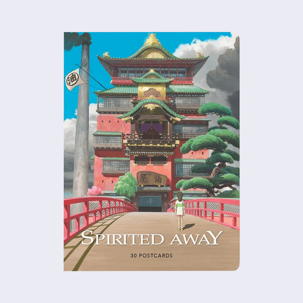 Box of postcards with a full bleed cover image of Spirited Away scene with a small girl (Chihiro) standing on a large wooden bridge looking at a multi-level intricate bathhouse. "Spirited Away" is written in logo font at the bottom along with "30 Postcards".