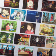 Multiple postcards laid out, showing variety in designs. Screenshots are all different scenes from movie Spirited Away, such as ducks in a hot bath, Chihiro standing in the bathhouse, Chihiro sitting on a train with No Face, etc.