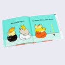 Open book spread featuring illustrations of cartoon cats stacked atop of one another with counting.