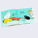 Open book spread featuring illustrations of cartoon cats stacked atop of one another with counting.