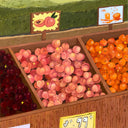 Painting of a fruit stand made out of wood with many peaches in one segment, oranges in another and plums in a final. Cartoon style signage hangs from the dispaly.