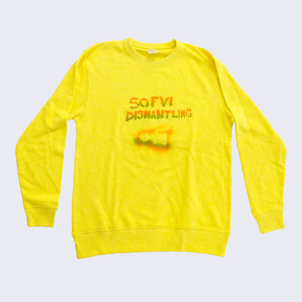 Front of bright yellow crewneck sweatshirt. Center chest area has stenciled text in orange and green gradient that says sofubi dismantling.