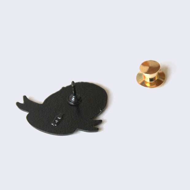 Back of enamel pin with gold metal pin backing.