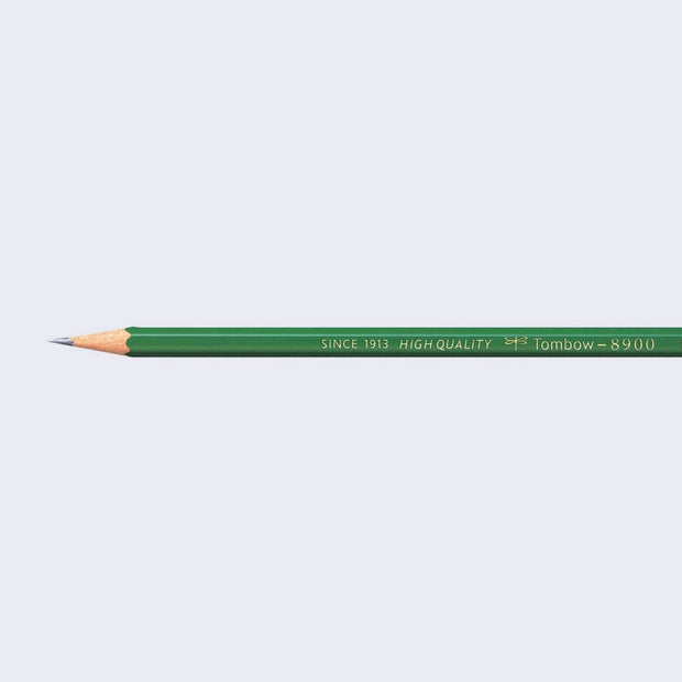 A sharpened Tombow brand pencil, with a forest green body.