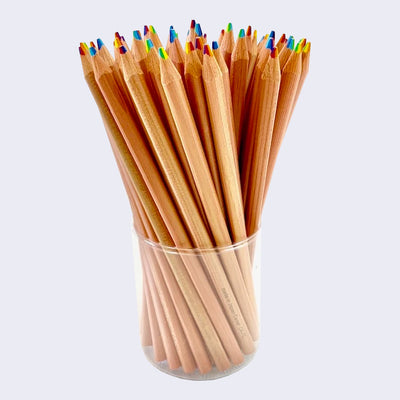 Clear cup holding multiple natural wood pencils with rainbow writing tips.
