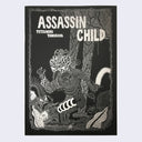 "Assassin Child" cover, with intricate silver ink illustrations of slimy alien creatures in an alien jungle on black paper.