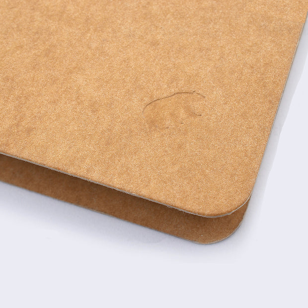 Close up of kraft colored notebook with small embossment of a bear.