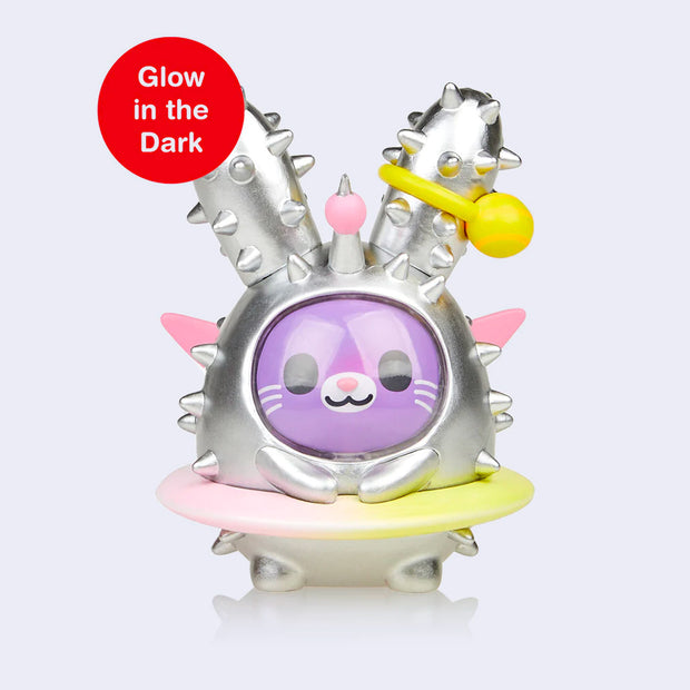 Vinyl purple bunny figure with a round, metallic silver body with spikes like a cacti. Its exterior is like a space suit, with a clear covering over its face and a ring around its body like a planet. 