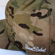 Close up of the cursive text embroidered on left side of camo cap that says giant robot.