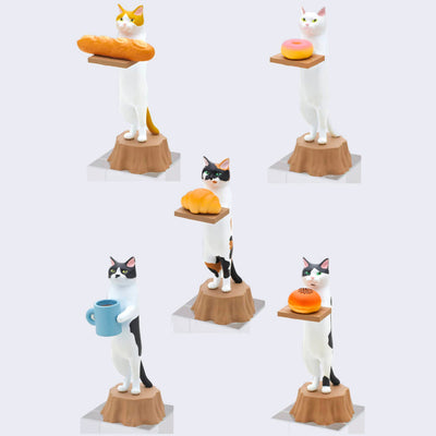 5 differently designed cat figures, all standing tall on a tree stump while holding a bakery item. Items being held include baguette, pink donut, croissant, bean bun, and blue coffee mug.