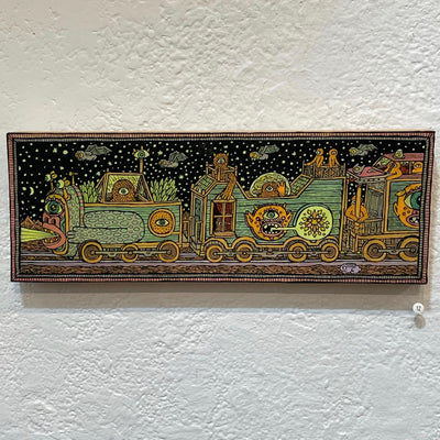 Illustration on wood of a nighttime train scene, the train made up of variously shaped monsters. The passengers include a variety of orange cyclopses, riding atop and inside.
