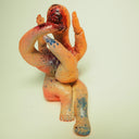 Clay sculpture of a body horror amalgamation of limbs, with an open, bloody mouth where the "head" would be.