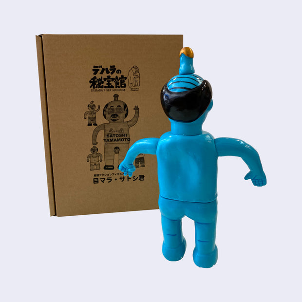 Back view of blue painted soft vinyl figure of a balding nude man with a gold tipped penis atop his head. One of his hands is formed into a peace sign.