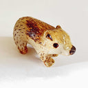 Small cute ceramic bear with a toasted coloring look, varying shades of brown. 