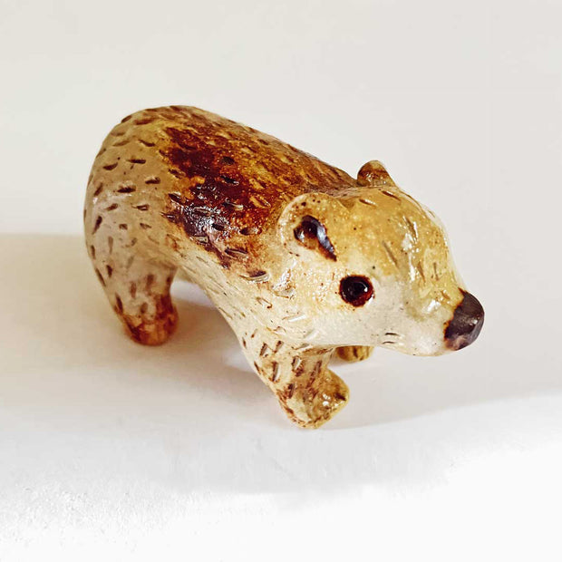 Small cute ceramic bear with a toasted coloring look, varying shades of brown. 