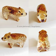 Small cute ceramic bear with a toasted coloring look, varying shades of brown.