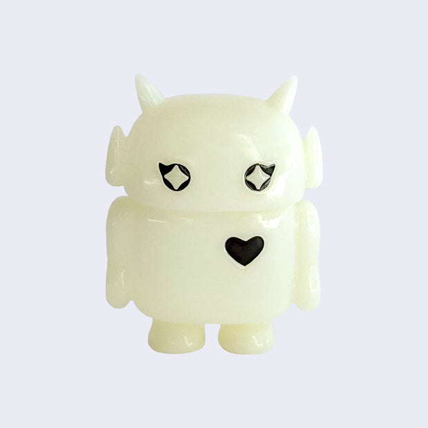Small light cream color soft vinyl figure, shaped like a smaller Big Boss Robot, with a bigger head than normal and two black eyes with sparkles as pupils. A black heart is on its upper right chest.