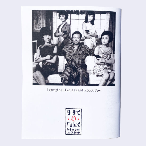 The back features an Asian man in a robe surrounded by four Asian women all pointing guns at the man. It says Lounging Like a Giant Robot Spy.