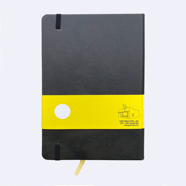 Backside of black pleather notebook with an elastic closure and yellow page marking ribbon.
