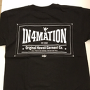 Back side of black t-shirt. On upper back is the information logo in a bowtie shape. Above the logo a small skeleton hand gives the shaka sign.