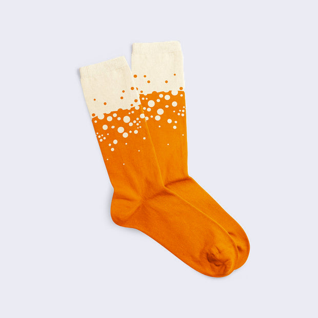 Pair of mid calf length socks, mainly orange with a cream colored top with a fizzing bubble design of polka dots, orange on the cream and cream on the orange.