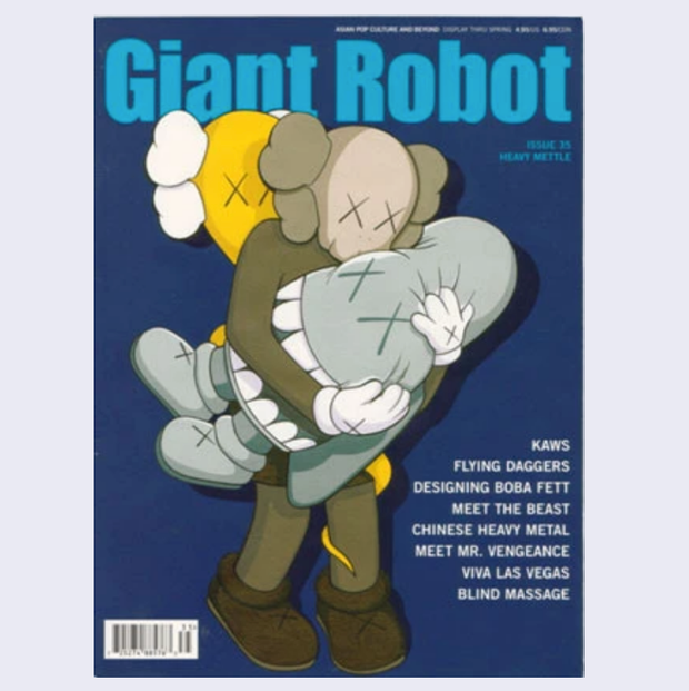 Giant Robot Issue #35 magazine cover, navy blue with "Giant Robot" written in light blue font across the top. Cover illustration features a Kaws cross eyed skull character standing and holding a smaller character wrapped in a sheet with cross eyes and a large mouth. A yellow skull cross eye figure is behind. Cover articles can be read in product description.