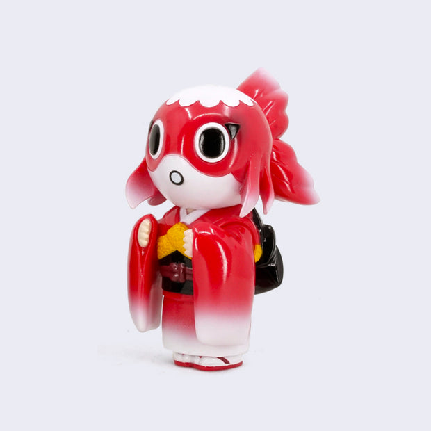 Soft vinyl standing figure with a red and white koi fish head, large black eyes and a small open mouth. It wears a red to white ombre kimono with traditional accessories and sandals.