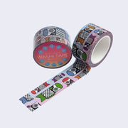 Two rolls of washi tape, one is wrapped and the other is rolled out to display pattern of blue to pink ombre tape with different color and sized cartoon fish flags. Colors include green, red, purple, blue and orange.