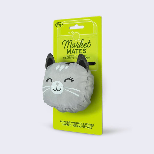 A smiling, gray and white cat attached to a green hang tag by a clip. "Market Mates" is written on the tag.