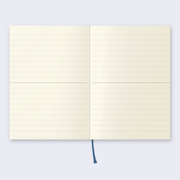 Open page spread of the notebook displaying lined cream colored paper and a dark ribbon for place marking.