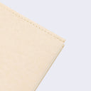 Close up of cream color notebook cover, showing thread binding.