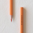 Sharpened orange color pencil and the bottom of another pencil, with "MD Paper Products" written in all caps on the side.