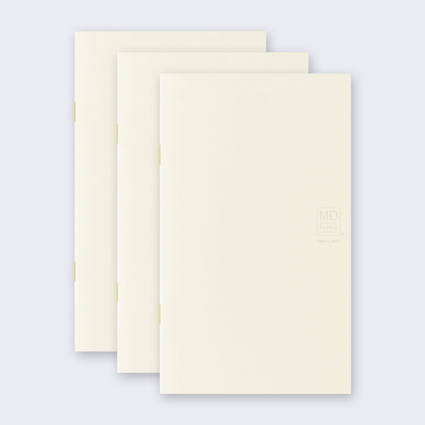 3 cream colored blank notebooks, stacked up on one another.