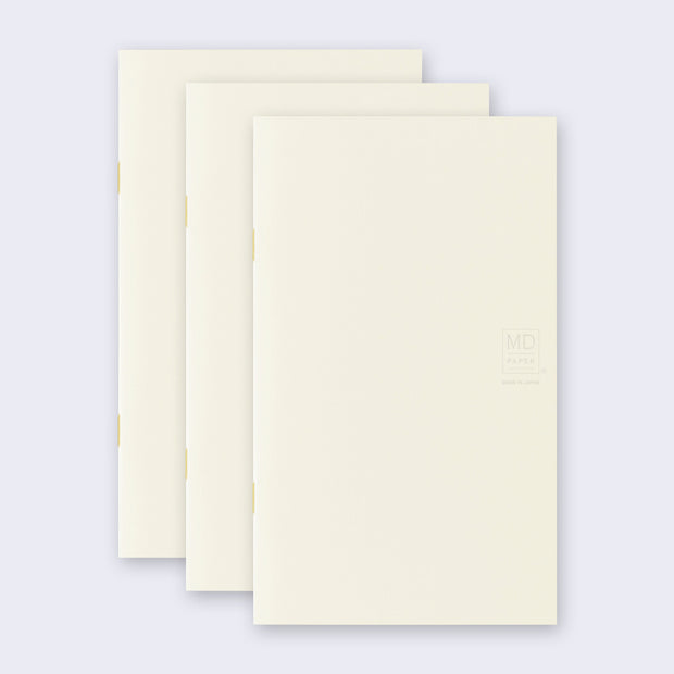 3 cream colored blank notebooks, stacked up on one another.