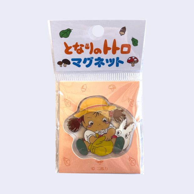 Mei sitting and searching through a tan pouch in her lap, while white Chibi Totoro looks over her shoulder in a decorated plastic sleeve