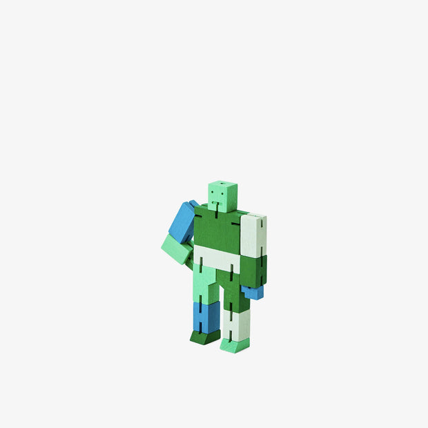 Wooden robot made of square-like shapes, standing with an arm on its hip. It is various shades of green and some blue.