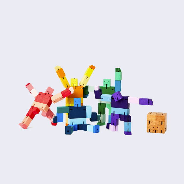 6 wooden robots made of geometric shapes, all with different poses. Colors include natural wood, shades of red, yellow, blue, purple or green. 