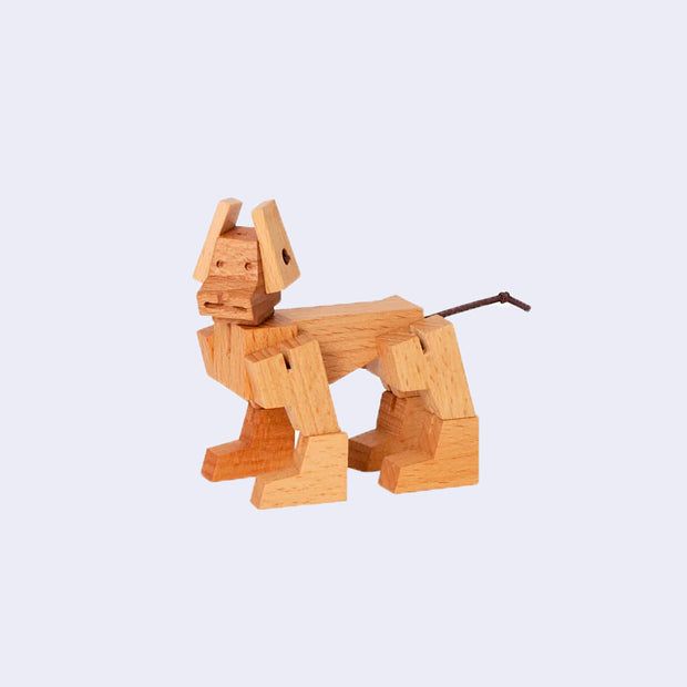 Wooden dog made of many geometric shapes, standing on its legs.