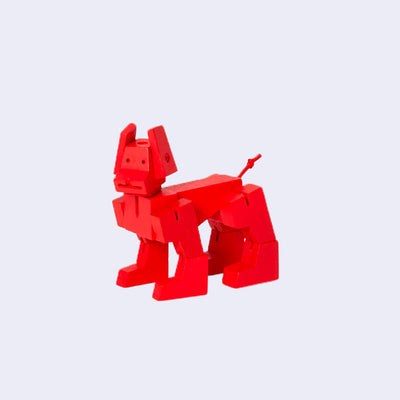 Red wooden dog sculpture made up of many different geometric shapes.