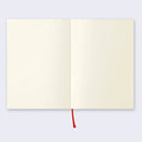 Open page spread of the notebook displaying blank cream colored paper and a red ribbon for place marking.