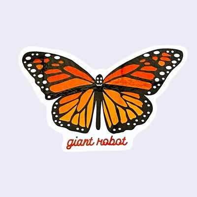 White cut out sticker with a brightly colored monarch butterfly, wings open. "Giant Robot" is written in dark orange cursive along the bottom.