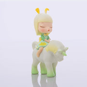 Vinyl figure of a young girl with blonde hair and bunny ears on a pastel white to green ombre unicorn, both with their eyes closed.